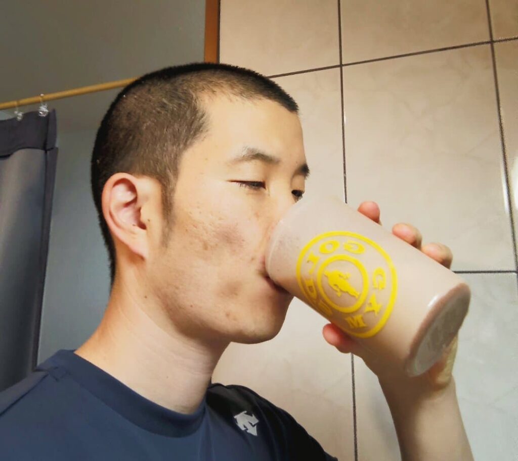 飲むヨーグルトで混ぜたプロテインを飲む男性