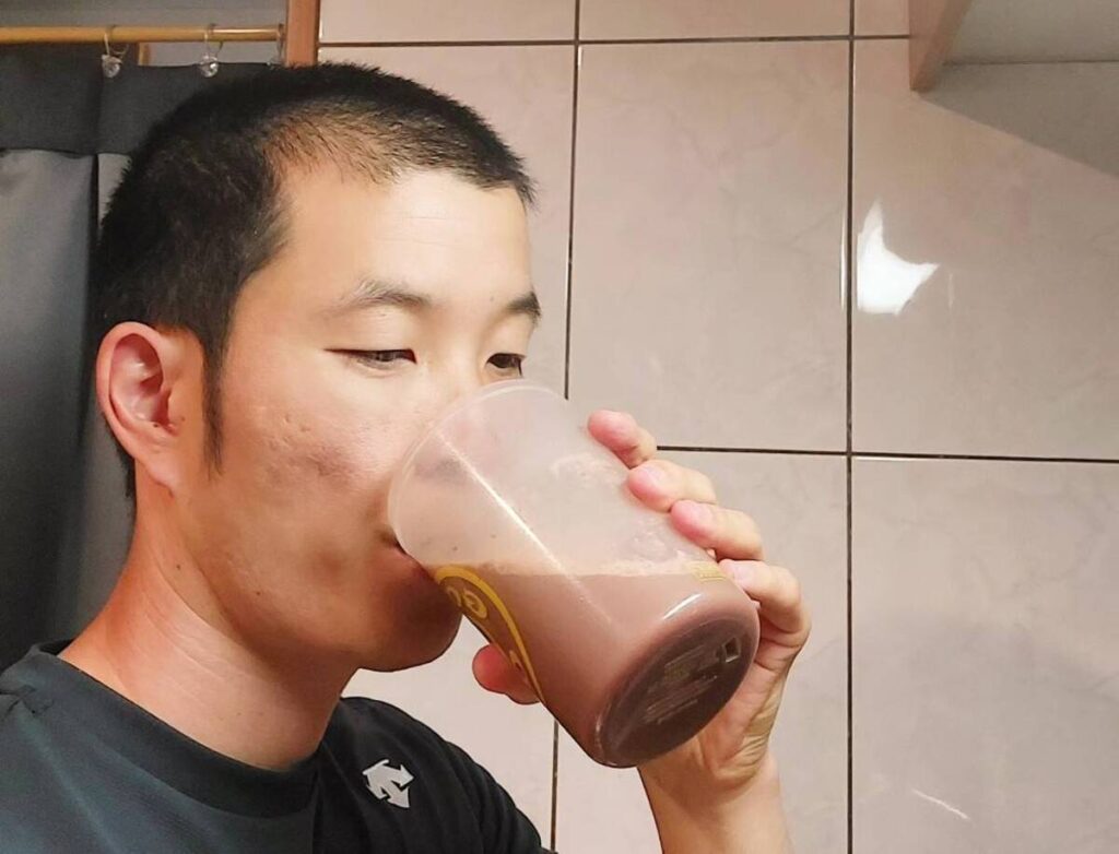 炭酸水で割ったプロテインを飲む男性