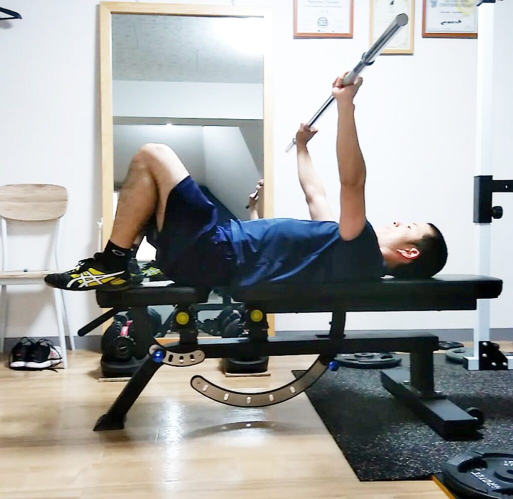 ベンチの上に足を上げて行うベンチプレスのやり方の説明