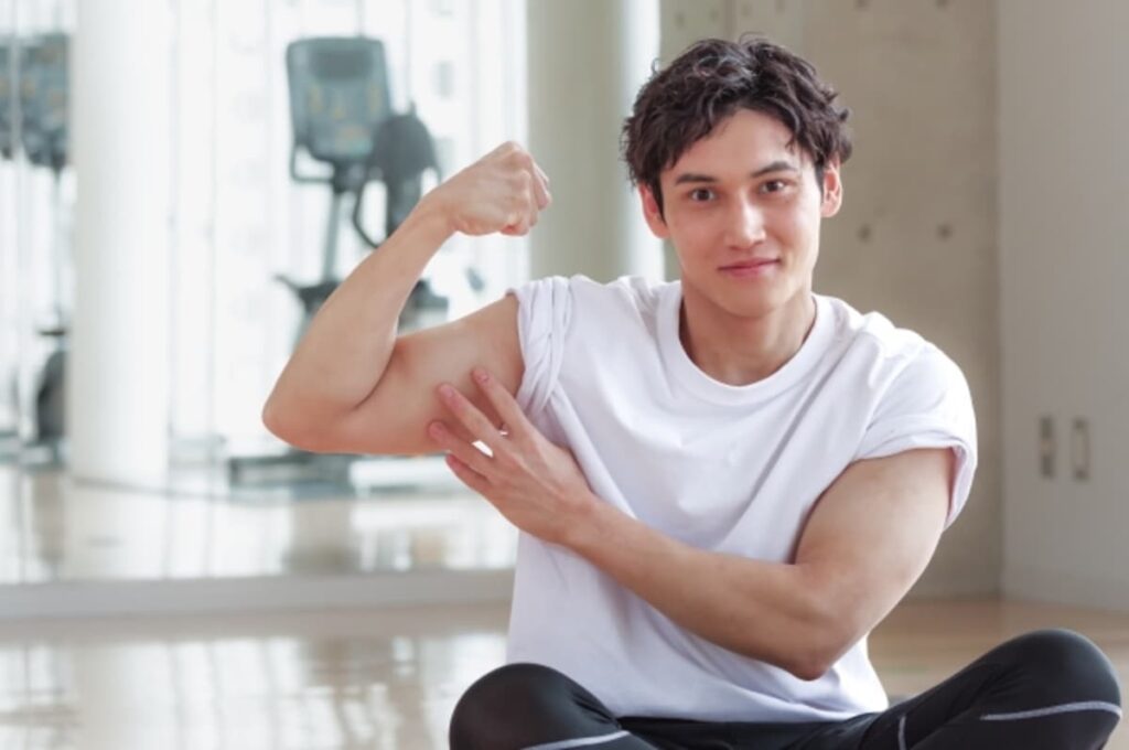 力こぶ(上腕二頭筋)を見せる男性